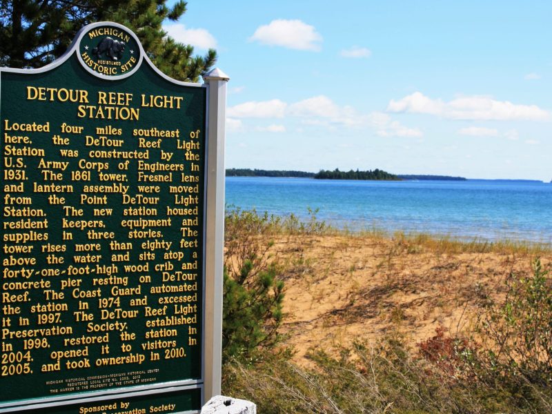 DeTour Township's DeTour Reef Light Station sign and view of beach and water