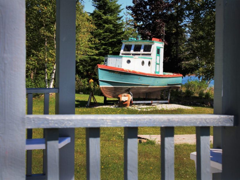 DeTour Village's DeTour Botanical porch view to a boat on a lawn