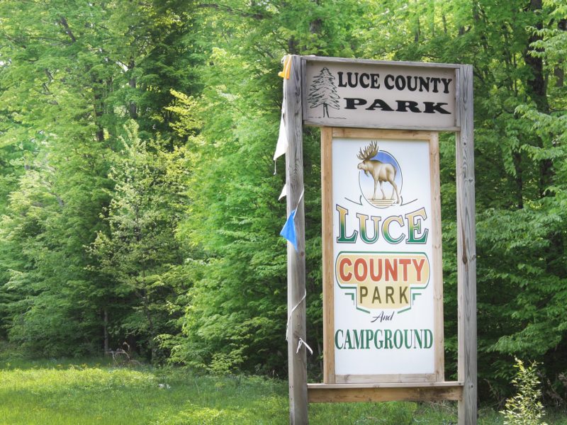 Luce County Park and Campground wooden sign in front of woods