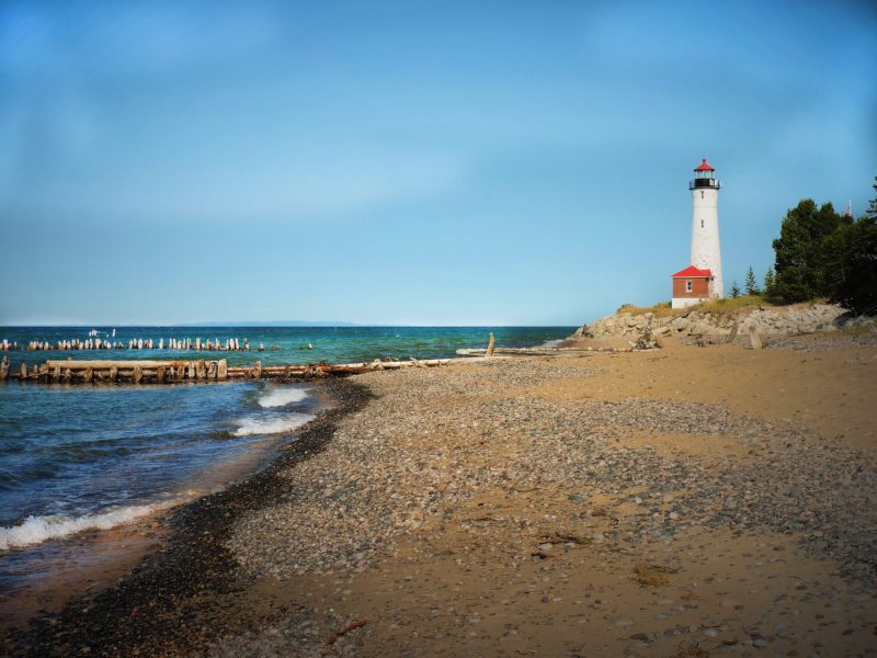 Beach shoreline with McMillan Township's Crisp Point Lighthouse in distance